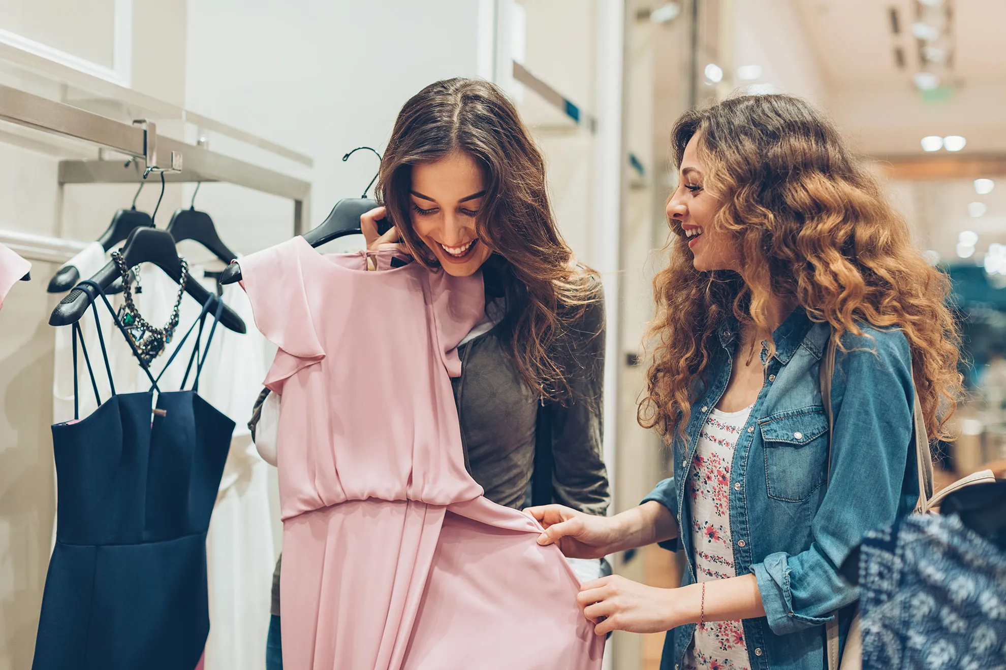 Two women in a retail store looking at clothes