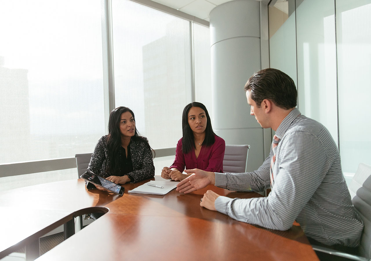 Three business people talking around a table