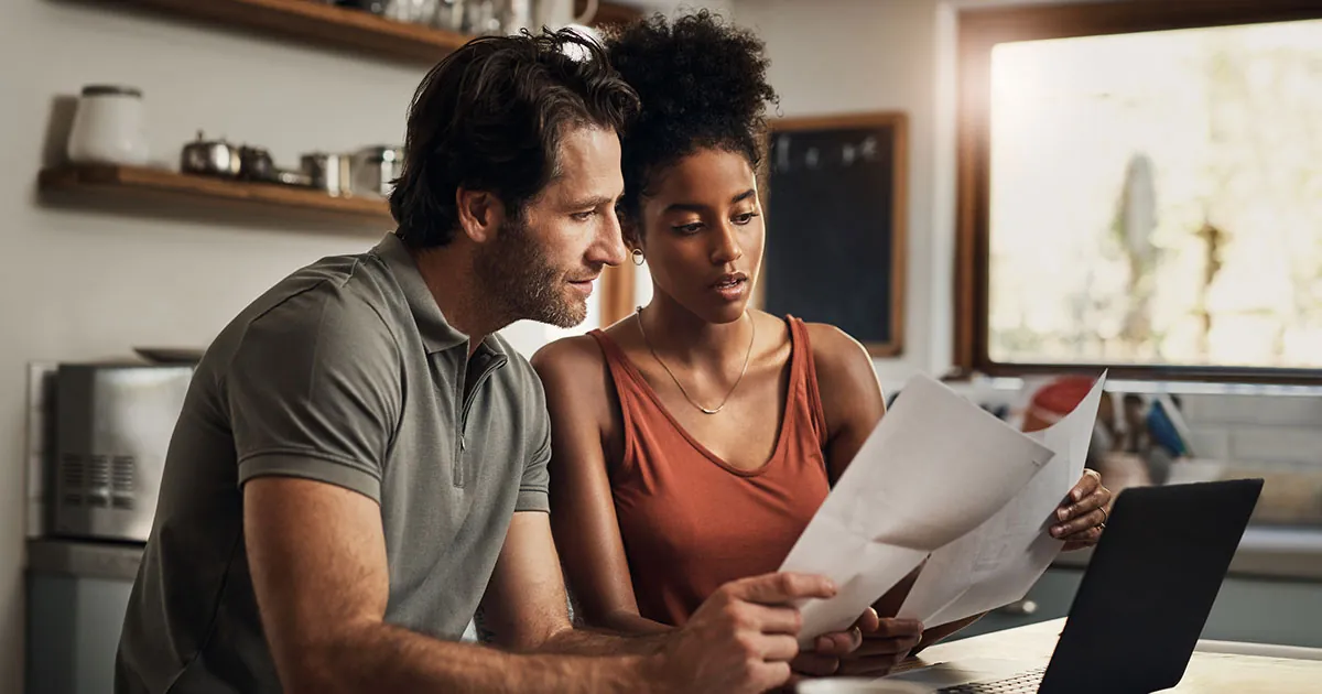 A man and a woman looking over an insurance policy packet together.