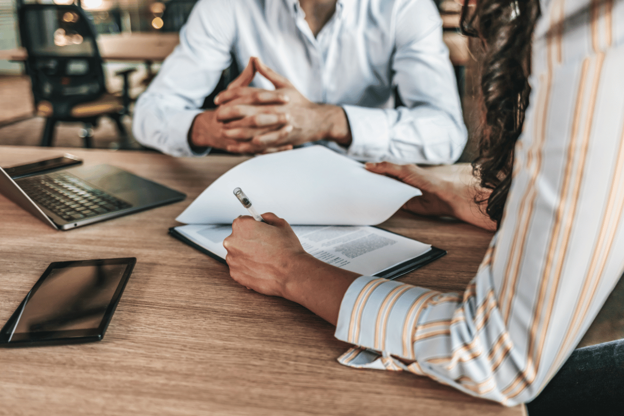 Allianz + InMoment customer story feature image talking about customer experience in insurance - image of two business people talking at a table