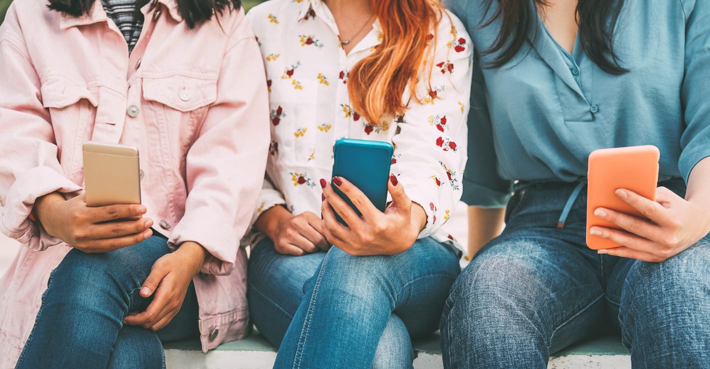 Happy friends using mobile smart phones outdoors