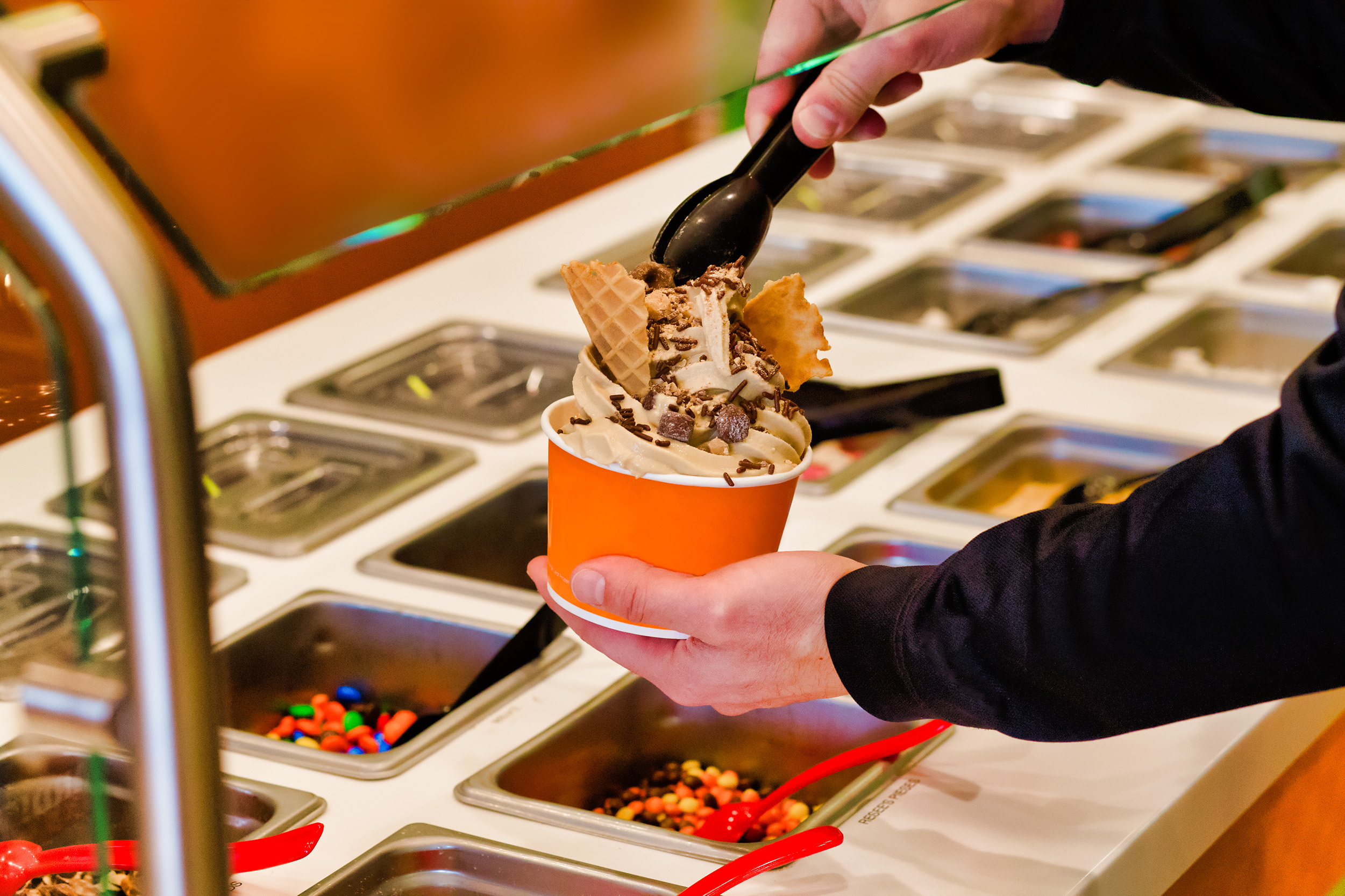 Making frozen yogurt with chocolate chips and sprinkles at the buffet